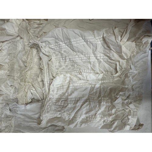 720 - Late 19thC/early 20thC linens to include 14 christening gowns, a camisole, nightdress and silk cream... 