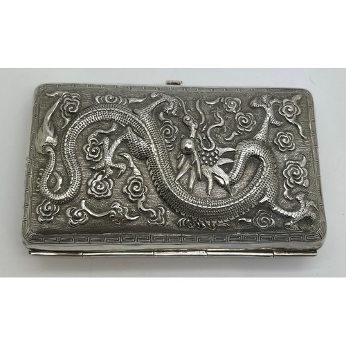 929 - A Chinese silver cigarette case with repoussé decoration, a fight scene to one side, dragon to the r... 