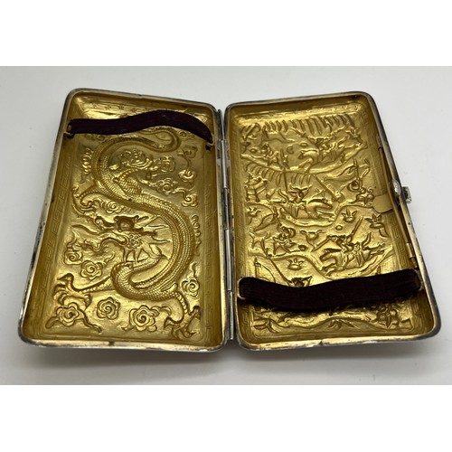 929 - A Chinese silver cigarette case with repoussé decoration, a fight scene to one side, dragon to the r... 