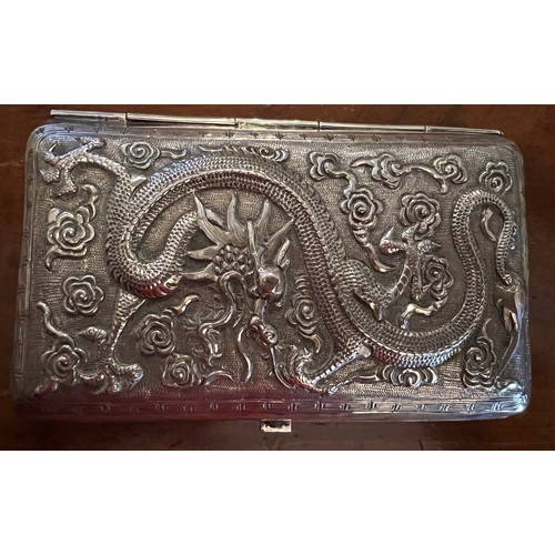 929 - A Chinese silver cigarette case with repoussé decoration, a fight scene to one side, dragon to the r... 