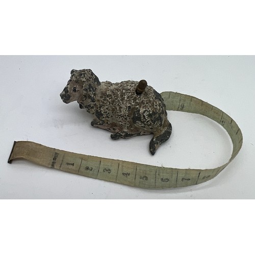 1271 - An early 20thC metal sheep tape measure. 5cm l. Measures centimetres and inches.