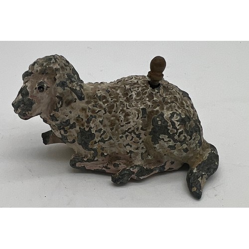 1271 - An early 20thC metal sheep tape measure. 5cm l. Measures centimetres and inches.