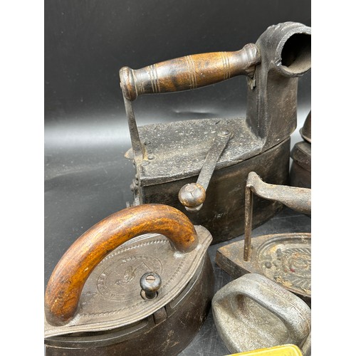 1278 - A collection of sad irons, CH Crane, Otto etc together with various tins to include Rowntree's Biscu... 