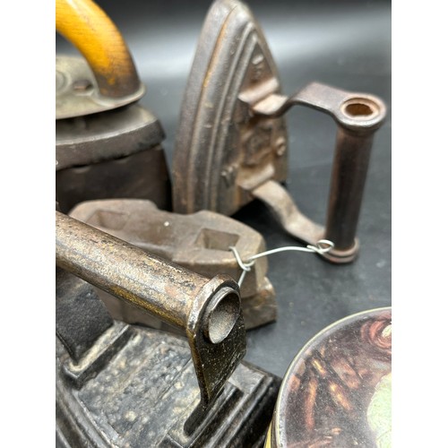 1278 - A collection of sad irons, CH Crane, Otto etc together with various tins to include Rowntree's Biscu... 