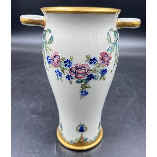 204 - A William Moorcroft for Macintyre Burslem vase with floral garlands and rosettes. 19cms. Stamped to ... 