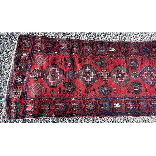 1103 - A red ground wool carpet runner 273 x  80cm.