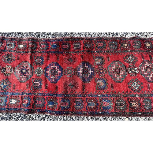 1103 - A red ground wool carpet runner 273 x  80cm.