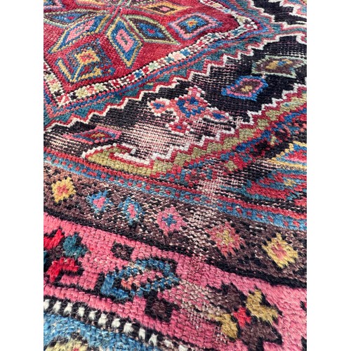 1104 - An orange and blue ground wool rug. 278cm x 131cm.