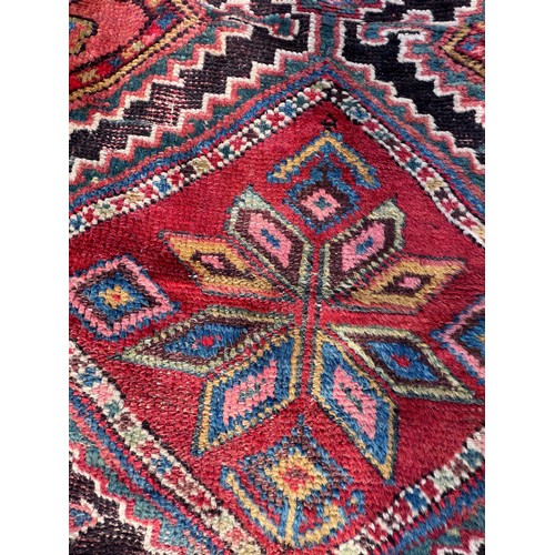 1104 - An orange and blue ground wool rug. 278cm x 131cm.