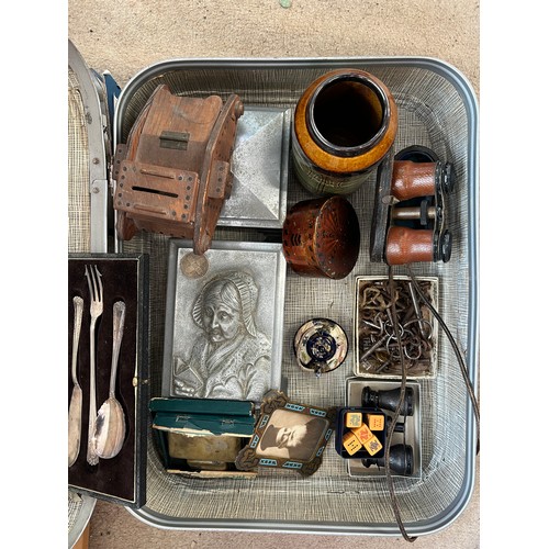 1306 - A vintage suitcase and contents to include wooden tank money box dated 1946, opera glasses, metal mu... 