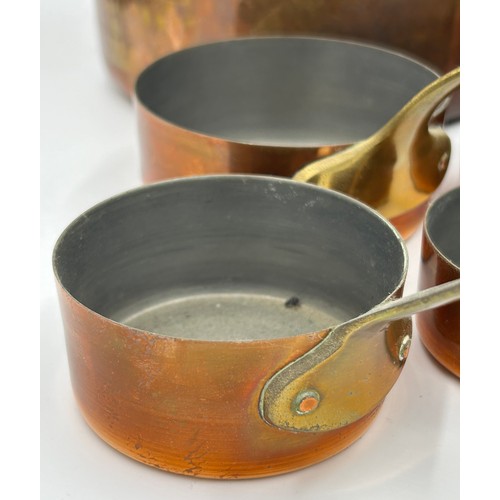 415 - Set of 7 French copper pans, the larger two with cast iron handles, the smaller ones with brass hand... 