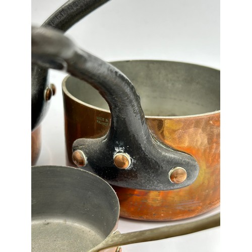 415 - Set of 7 French copper pans, the larger two with cast iron handles, the smaller ones with brass hand... 