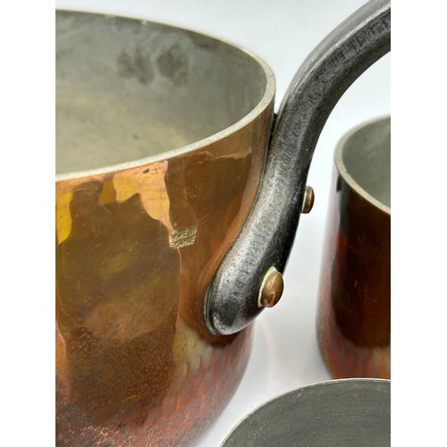 415 - Set of 7 French copper pans, the larger two with cast iron handles, the smaller ones with brass hand... 