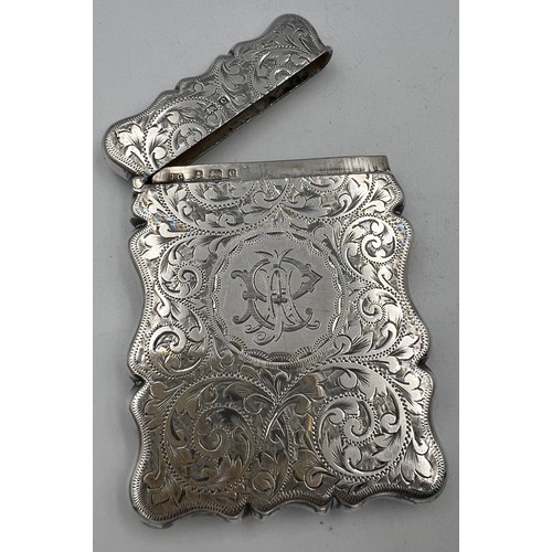 912 - A silver card case with foliage scroll engraving and initials to front. 9cm x 6.5cm. Birmingham 1902... 