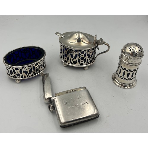 913 - A three piece silver cruet with blue glass liners Birmingham 1900/1919, a plated mustard spoon and a... 