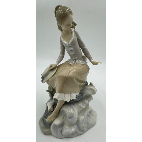 151 - Three Lladro figurines to include 'At the seaside', 'Washing up girl' 23cm h, and 'Friendship.