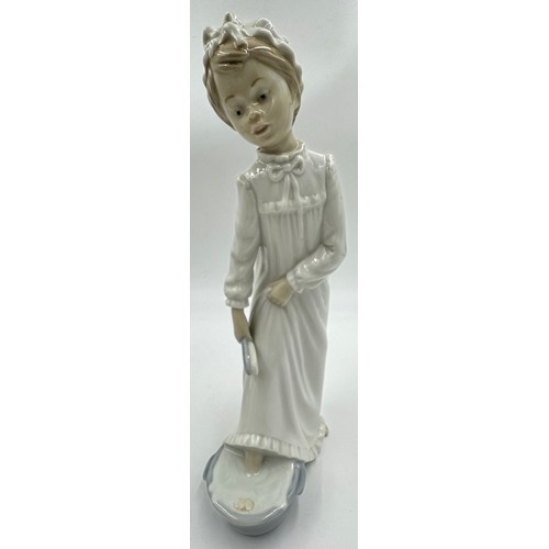 151 - Three Lladro figurines to include 'At the seaside', 'Washing up girl' 23cm h, and 'Friendship.