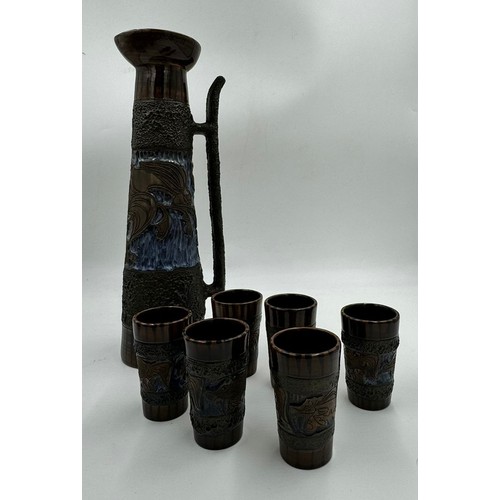 152 - Selection of studio type ceramics to include a tall jug with six tumblers, one Chameleon Ware vase, ... 