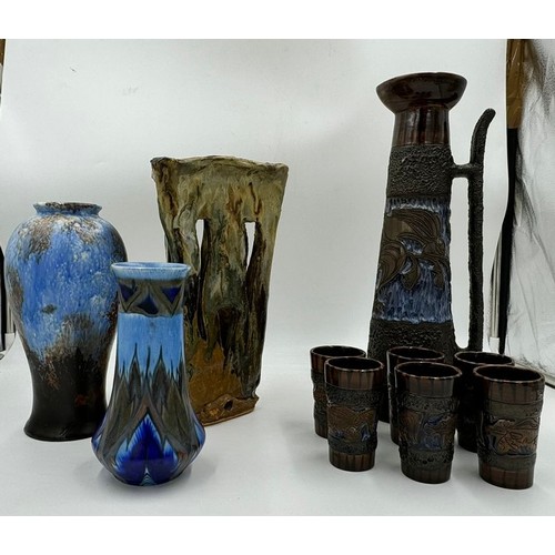 152 - Selection of studio type ceramics to include a tall jug with six tumblers, one Chameleon Ware vase, ... 