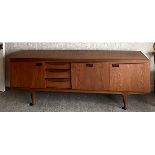 25 - A mid  20thC teak sideboard with three cupboards and three drawers 220cm l x 45cm d x 77cm h.