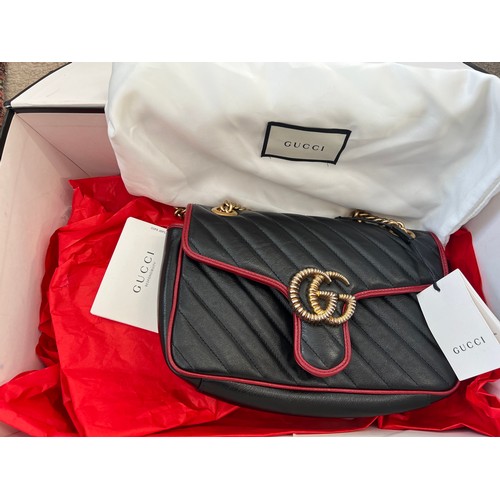 706 - A Gucci Marmont black with red trim and gold coloured chain hand bag, together with original box and... 