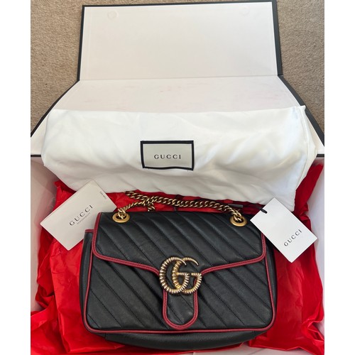 706 - A Gucci Marmont black with red trim and gold coloured chain hand bag, together with original box and... 