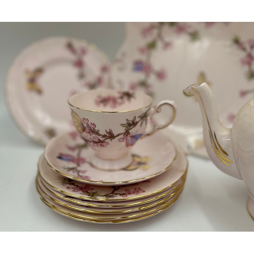 133 - A pink Tuscan bone china tea service with blossom and butterfly pattern (teapot, milk, sugar, 6 x cu... 