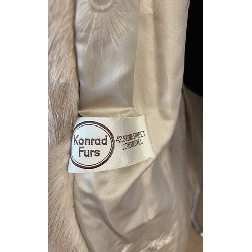 712 - A long pale mink fur coat with label for Konrad Furs Sloane Street London.