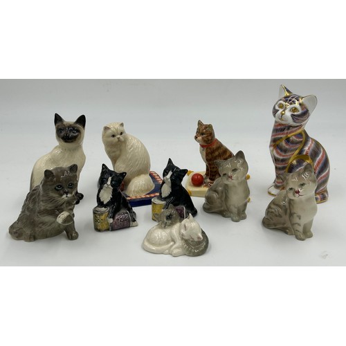 128 - A collection of ceramic cats to include a Royal Crown Derby seated cat with gold stopper (13cm) and ... 