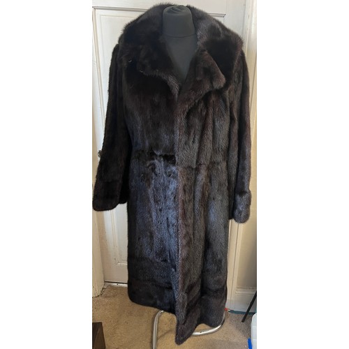 710 - A dark brown long mink coat together with two dark brown mink cuffs.