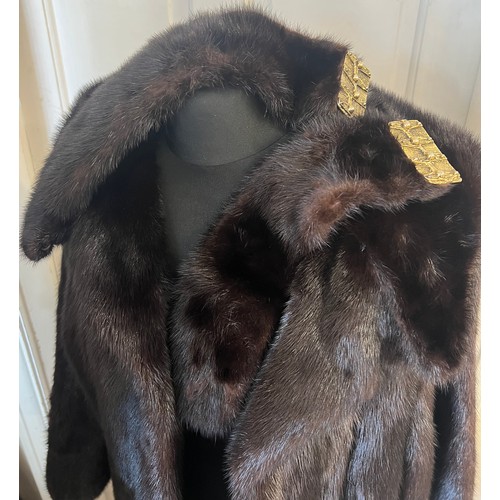 710 - A dark brown long mink coat together with two dark brown mink cuffs.