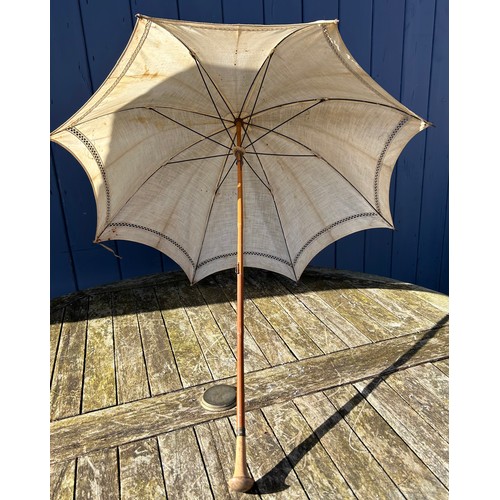 704 - Three Victorian bamboo parasols to include one with embroidered fabric and a carved swan handle and ... 