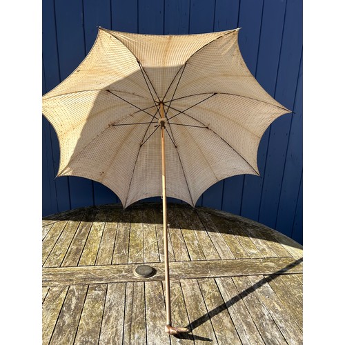 704 - Three Victorian bamboo parasols to include one with embroidered fabric and a carved swan handle and ... 