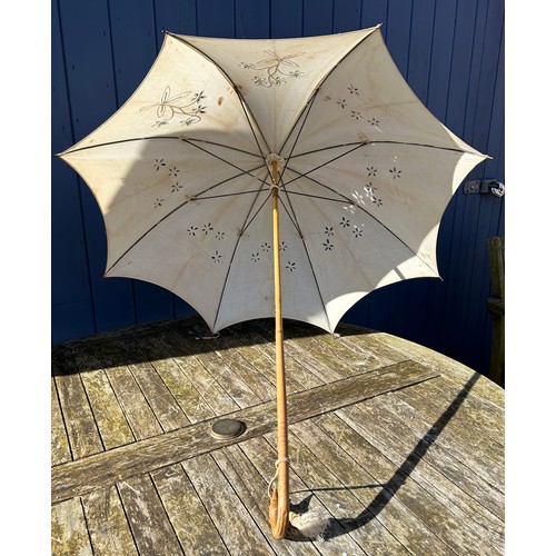 704 - Three Victorian bamboo parasols to include one with embroidered fabric and a carved swan handle and ... 