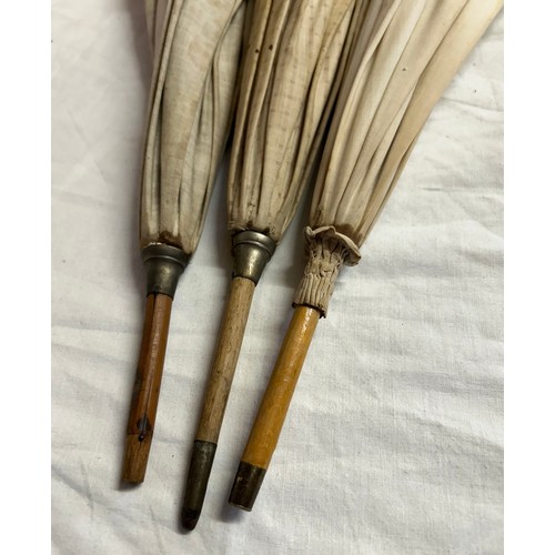 704 - Three Victorian bamboo parasols to include one with embroidered fabric and a carved swan handle and ... 