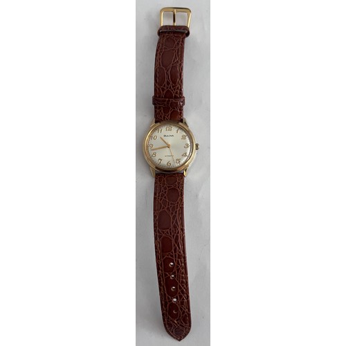 769 - A 1974 vintage automatic Bulova wristwatch, gold plated on brown leather strap with silver face. Wit... 