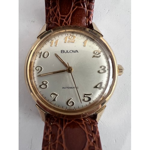 769 - A 1974 vintage automatic Bulova wristwatch, gold plated on brown leather strap with silver face. Wit... 