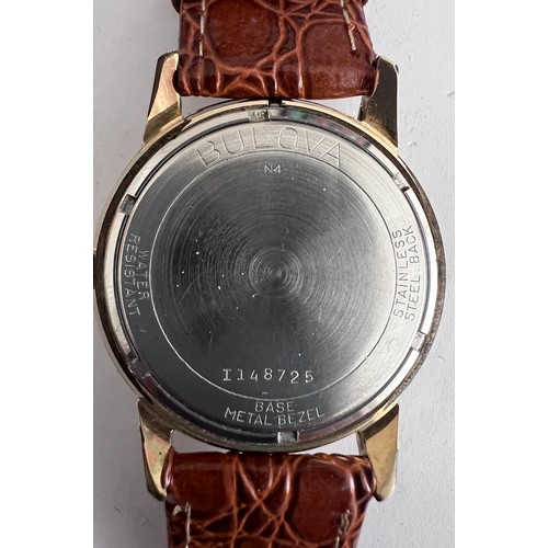 769 - A 1974 vintage automatic Bulova wristwatch, gold plated on brown leather strap with silver face. Wit... 