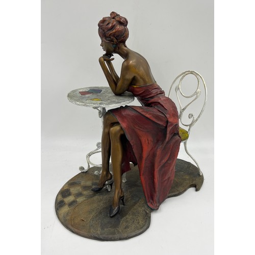 1353 - A heavy bronze Isaac Maimon sculpture ‘Anna’ A lady dressed in red seated at a table. 40cm h.