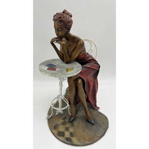 1353 - A heavy bronze Isaac Maimon sculpture ‘Anna’ A lady dressed in red seated at a table. 40cm h.