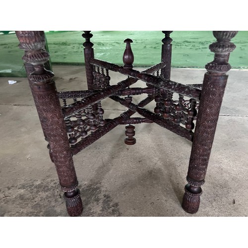 12 - A brass topped tiffin table with carved folding base. 75cm d.