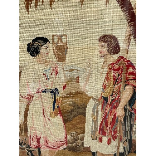 723 - An oak framed needlepoint tapestry depicting a shepherd and a water carrier. Tapestry 63 x 50cm.