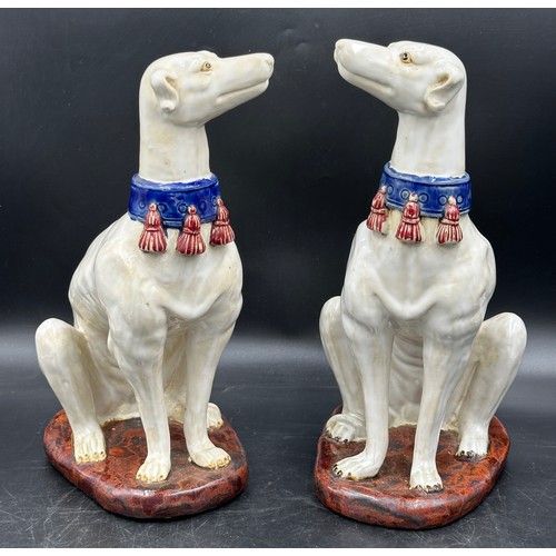 89 - A pair of large ceramic greyhounds in seated position. 35cm h.