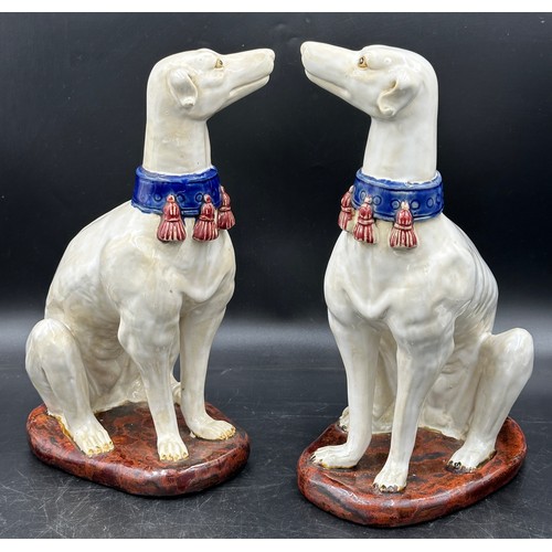 89 - A pair of large ceramic greyhounds in seated position. 35cm h.