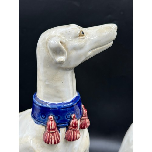 89 - A pair of large ceramic greyhounds in seated position. 35cm h.