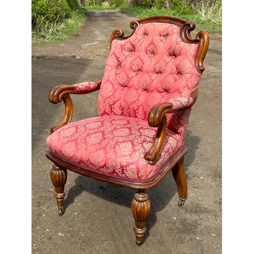 63 - An upholstered armchair with turned reeded legs and brass castors together with abutting footstool t... 