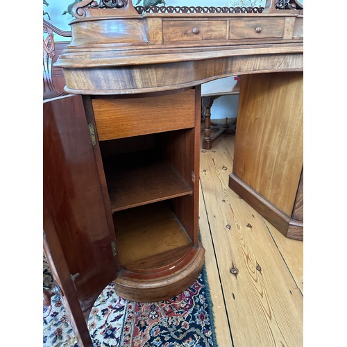 61 - A mahogany pedestal serpentine fronted dressing table with two cupboards to base with mirror back an... 