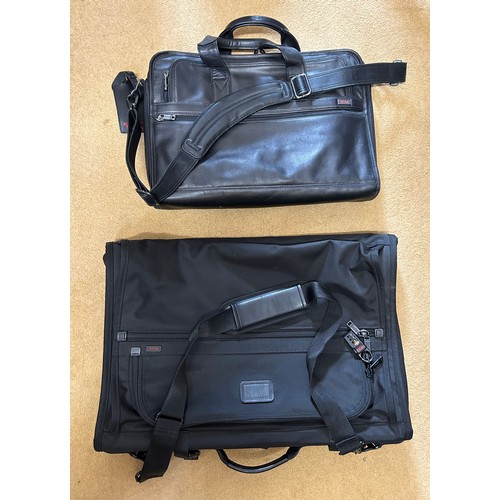 725 - A Tumi black leather briefcase/laptop bag together with a black Tumi suit carrier with leather handl... 