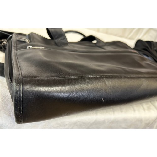 725 - A Tumi black leather briefcase/laptop bag together with a black Tumi suit carrier with leather handl... 