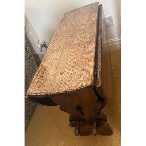 60 - An oak drop leaf circular side table. 91cm x 77cm open x 50cm h. 30cm w when leaves down.